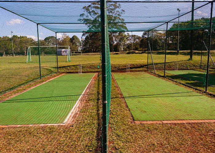Cricket practice batting bowling nets with astro turf pitch surface sports field .